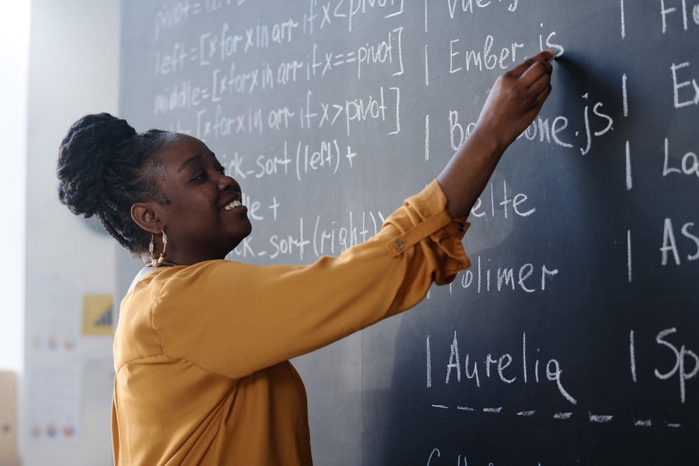 school teacher writing on blacknoard